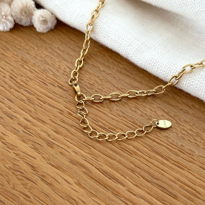 Instants Plaisirs – Collier "Lison" Acier, gros plan sur le fermoir et la chaînette d'extension d'un collier doré