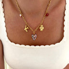 Instants Plaisirs – Collier "Lison" Acier, collier doré avec pendentifs colorés, porté par une femme en haut blanc
