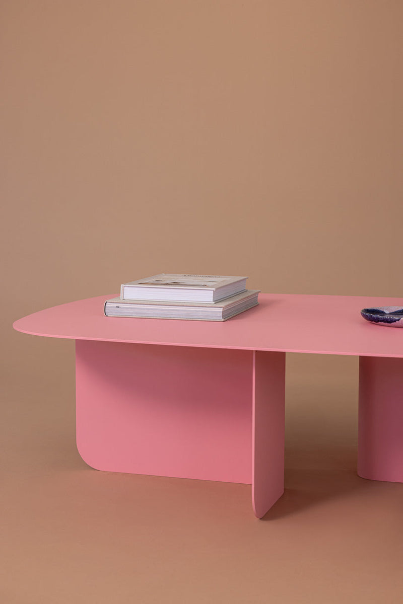 Stylischer Couchtisch LIVIA in Pink mit Büchern und dekorativen Elementen auf einer minimalistischen Oberfläche.