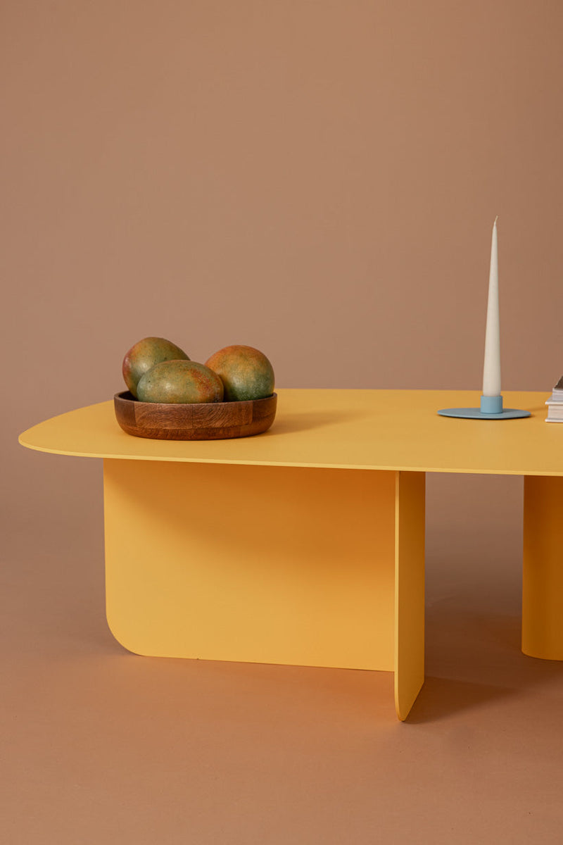 Stylischer Couchtisch LIVIA in gelber Farbe mit Obstschale und Kerze, ideal für moderne Wohnräume.