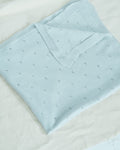 La Manufacture De Layette – Couverture Tricotée Ajourée - Vert D'Eau, couverture bébé bleu clair en maille, pliée sur fond blanc