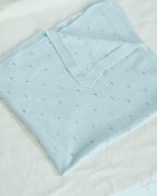 La Manufacture De Layette – Couverture Tricotée Ajourée - Vert D'Eau, couverture bébé bleu clair en maille, pliée sur fond blanc