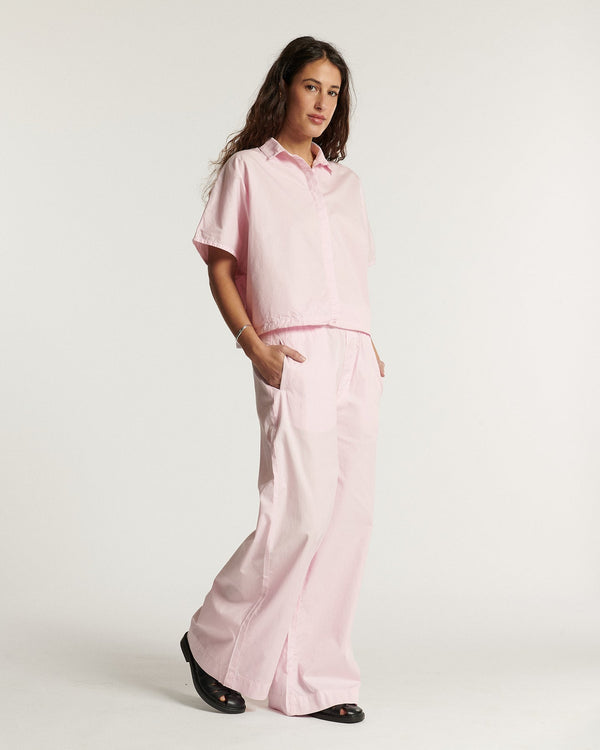 Wide pale pink cotton poplin pants, fluid and relaxed cut for a feminine and comfortable summer style.