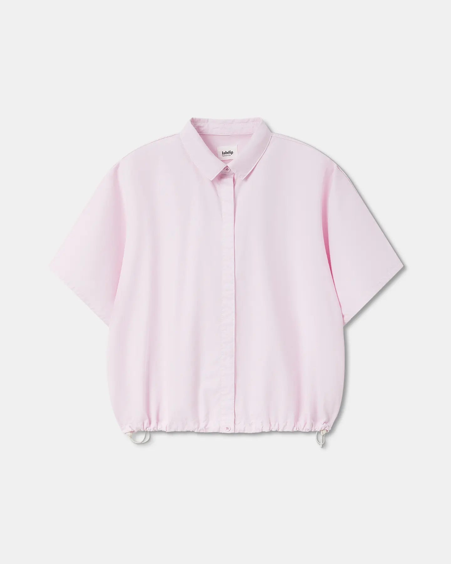 Chemisier femme en popeline légère rose clair avec col classique, manches courtes larges et bas ajustable par cordon de serrage pour un style décontracté.