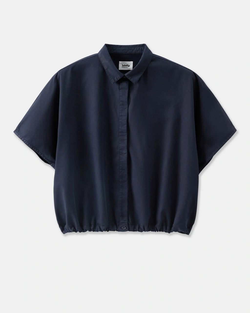 Chemise fluide en popeline bleu marine, coupe ample avec col classique et bas élastiqué, idéale pour un style décontracté et élégant.