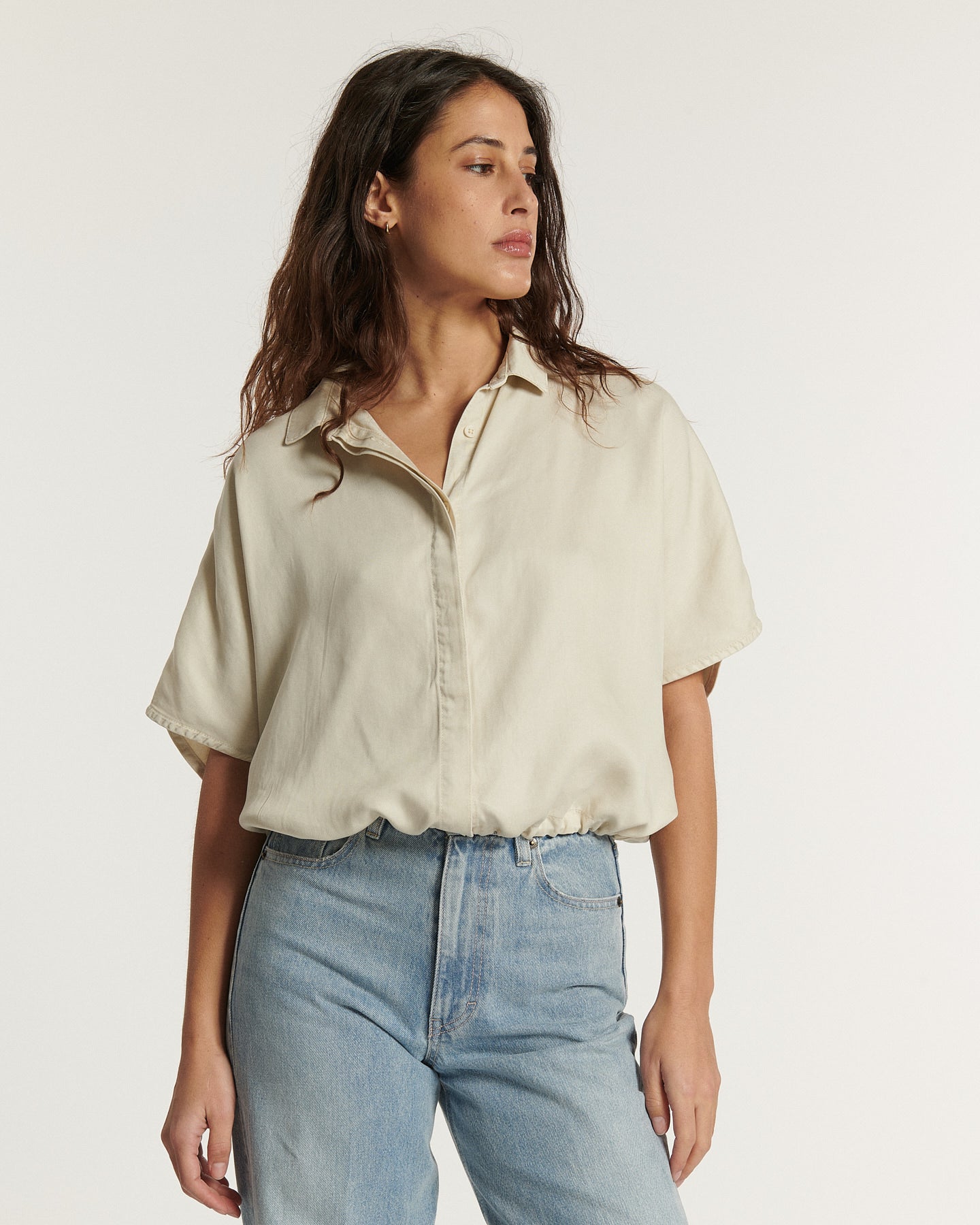 Jean pour femme en denim bleu clair, coupe droite et taille haute, offrant une silhouette confortable et élégante adaptée à toutes les morphologies.