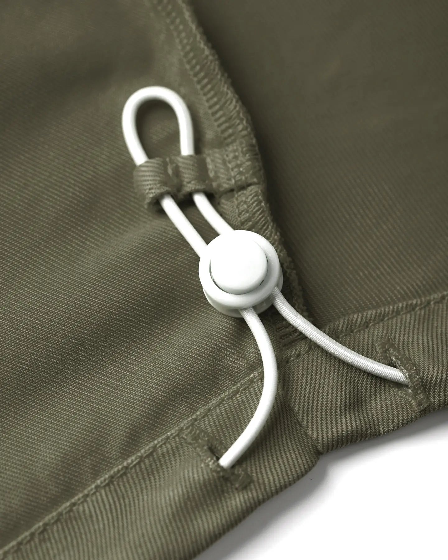 Détail d'un pantalon femme khaki en Tencel avec un cordon de serrage blanc ajustable, tissu fluide et doux au toucher, coupe confortable et adaptée à toutes les morphologies.