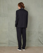 Officine Générale – Veste Arthus - Noir - Homme, mannequin de dos portant un costume noir sur fond vert
