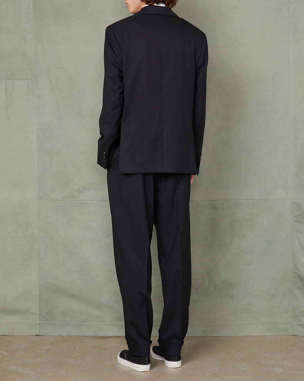 Officine Générale – Veste Arthus - Noir - Homme, mannequin de dos portant un costume noir sur fond vert