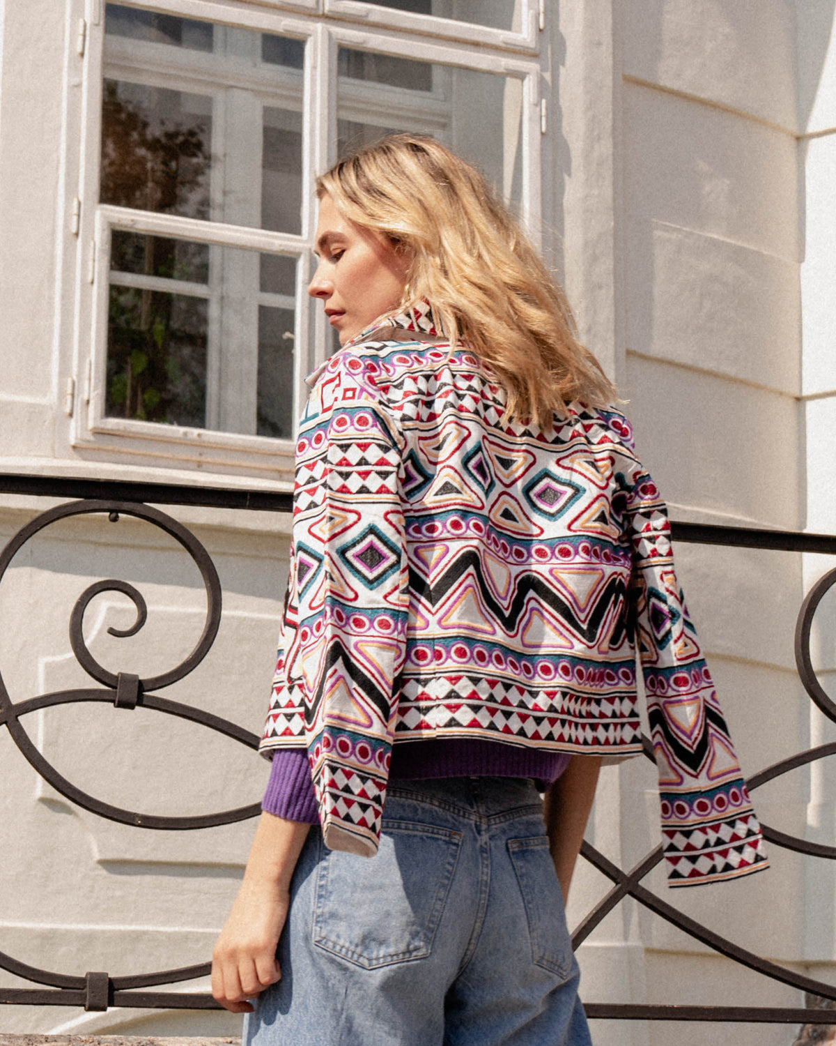 Michonet – Veste Rombo, mannequin de dos portant une veste colorée à motifs géométriques et un jean