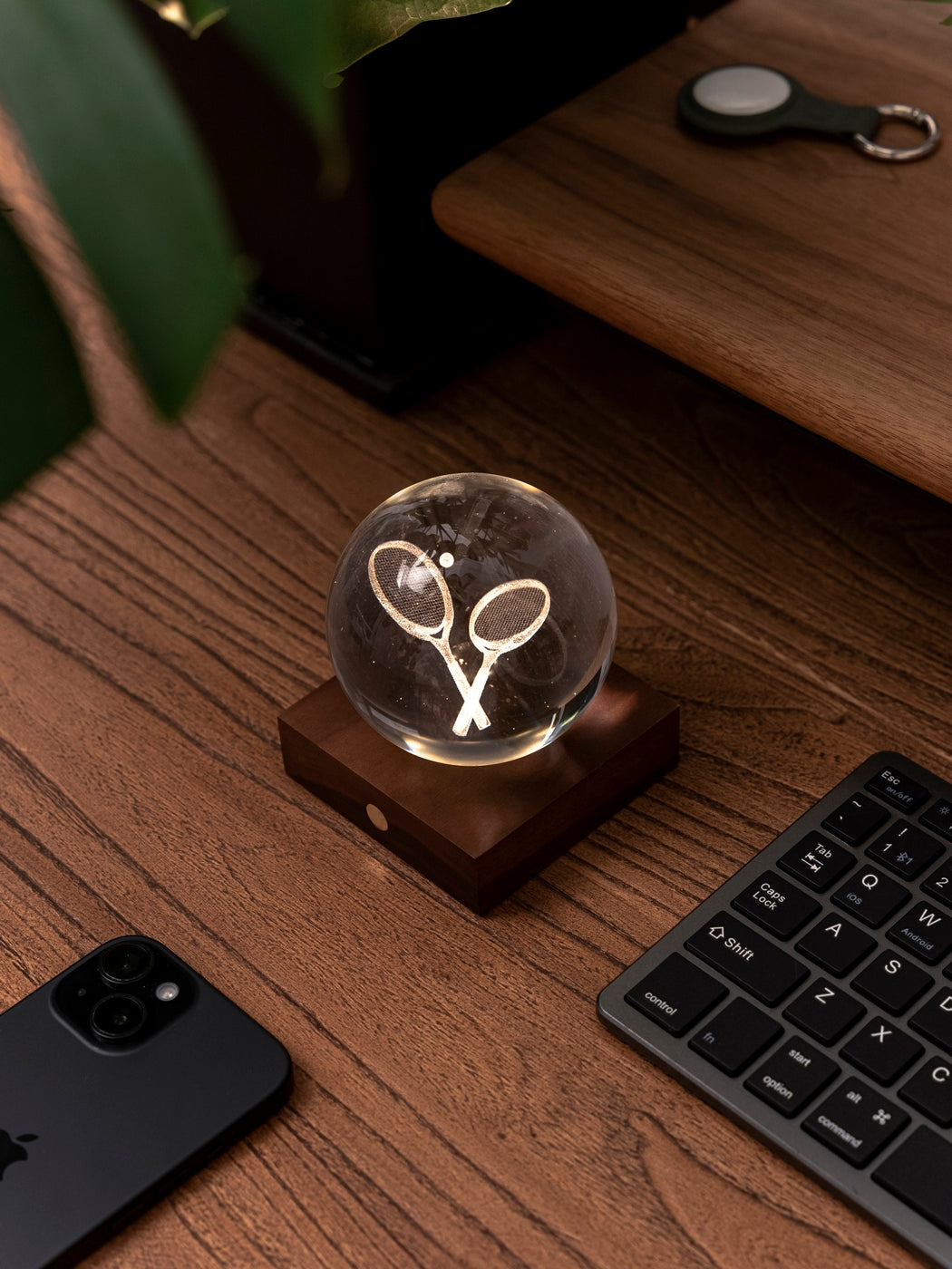 Gingko Design – Amber Crystal-lamp - Tennisracket, een kristallen bol met tennisrackets op een houten bureau