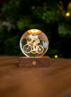 Gingko Design – Amber Crystal-lampa - Cyklist, glaskula med en graverad cyklist, stående på en träsockel