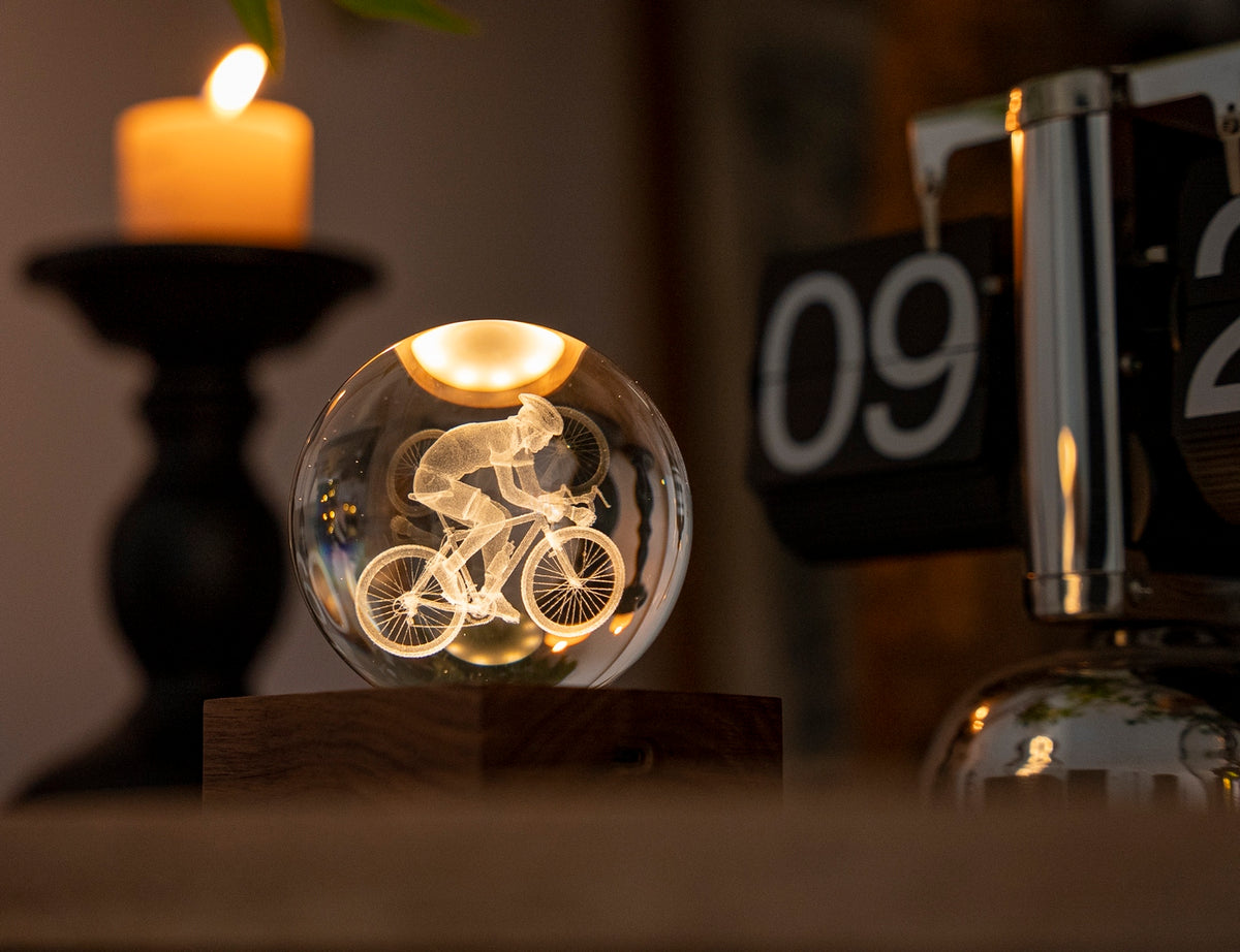 Gingko Design – Amber Crystal-lampa - Cyklist, en glaskula med en lysande cyklist på en träsockel