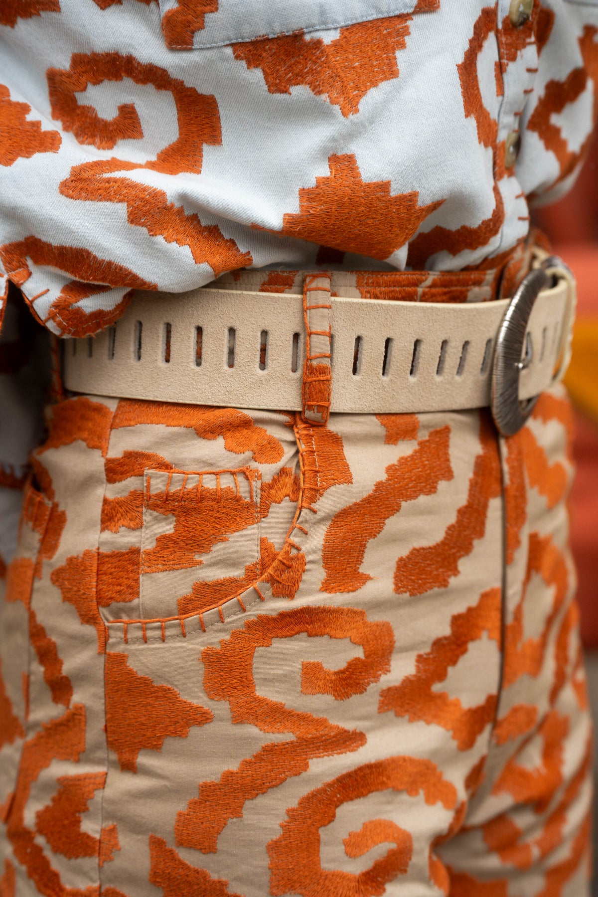 Michonet – Pantalon Etnico Orange, bukser og skjorte med orange og beige mønstre, båret med et bælte