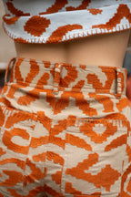 Michonet – Pantalon Etnico Orange, tøj set bagfra, orange mønster på beige baggrund, syningsdetalje