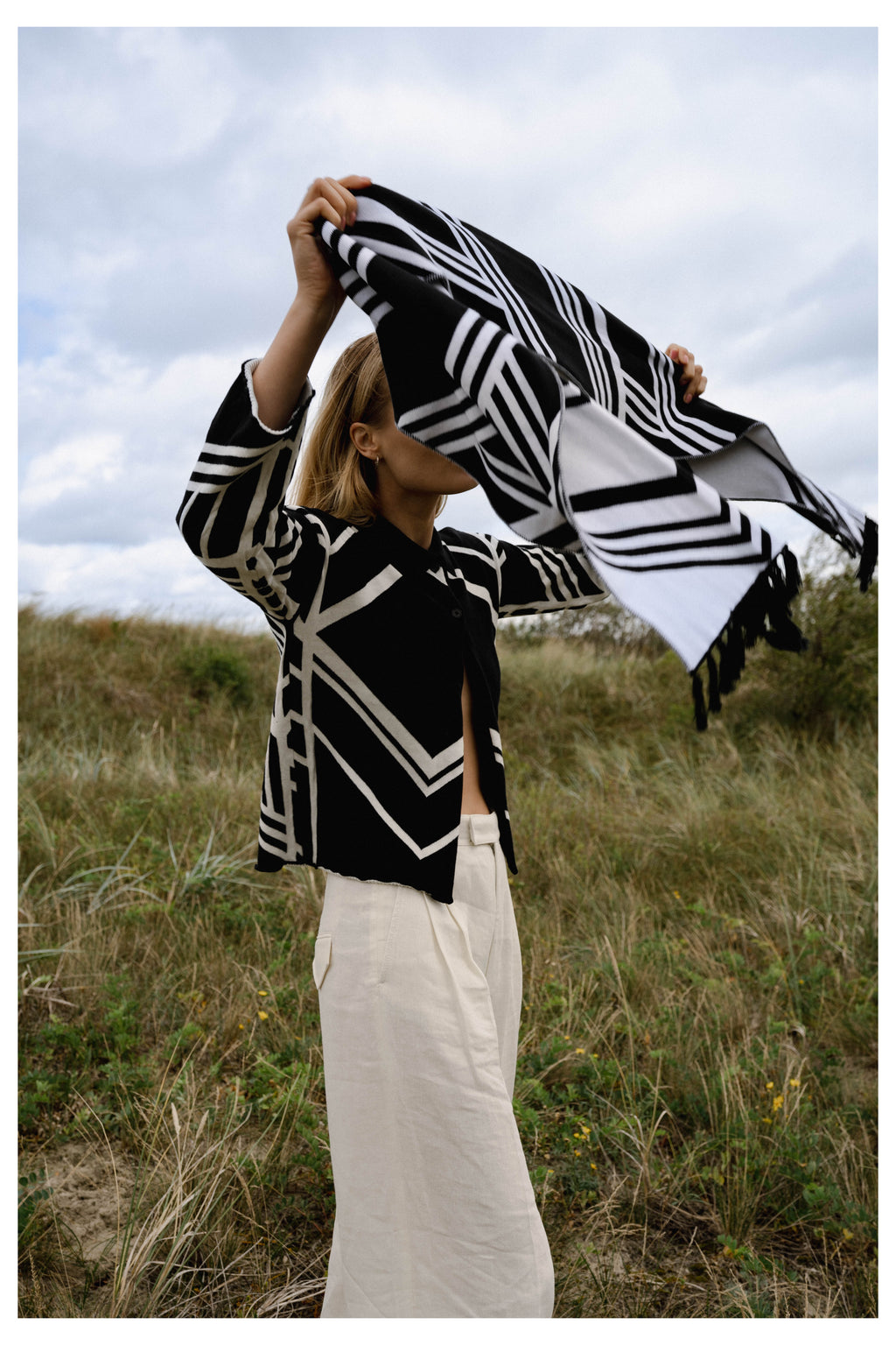 Michonet – Cardigan Set, mannequin de profil portant une veste noire et blanche et un pantalon clair