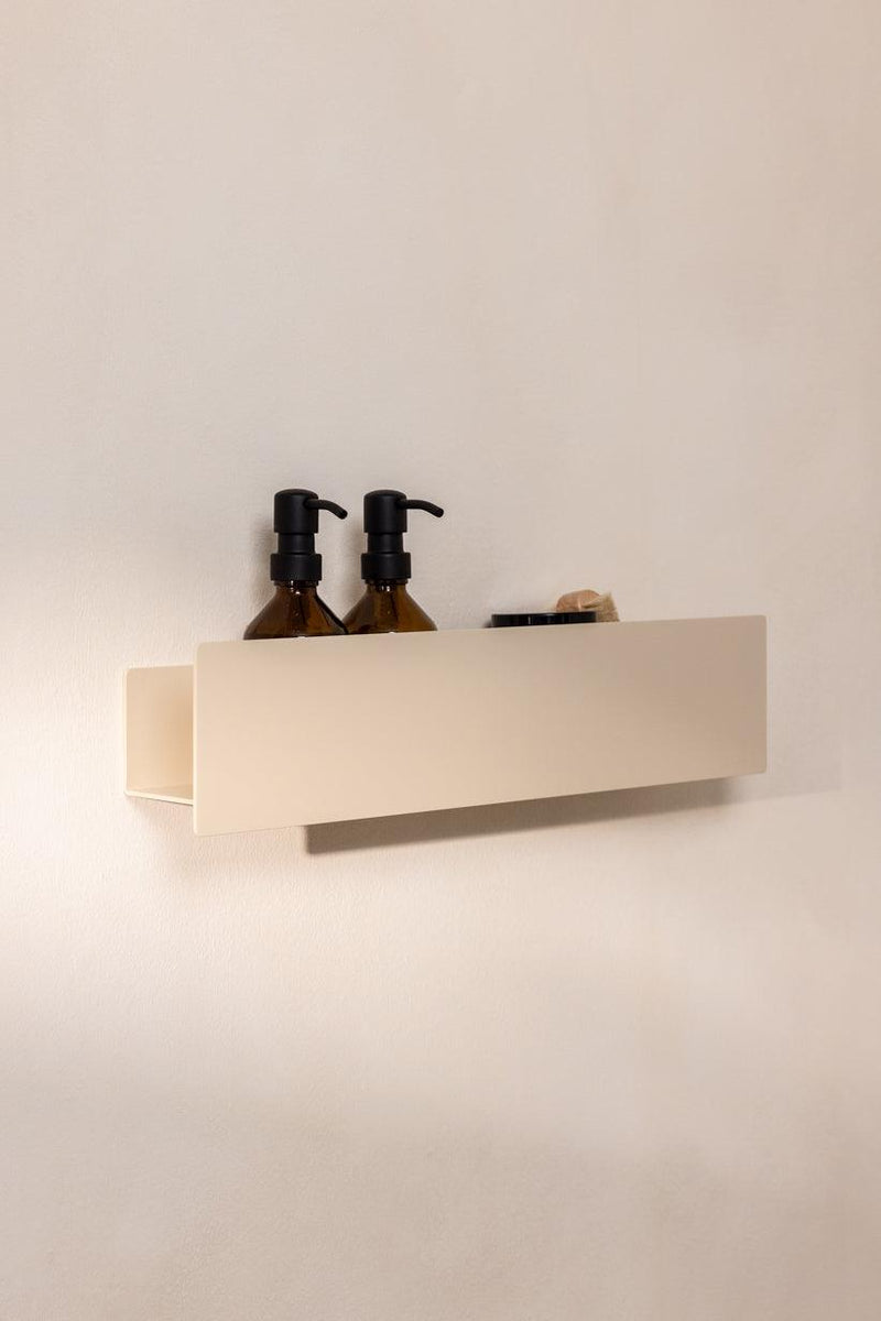 Duschablage SHEA mit Pflegeprodukten auf einer hellen Wand en diseño minimalista en aluminio.