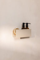 SHEA Duschablage aus Aluminium mit Shampoo- und Duschgel flask sowie evener Bürste in einem minimalistaischen Badezimmer.