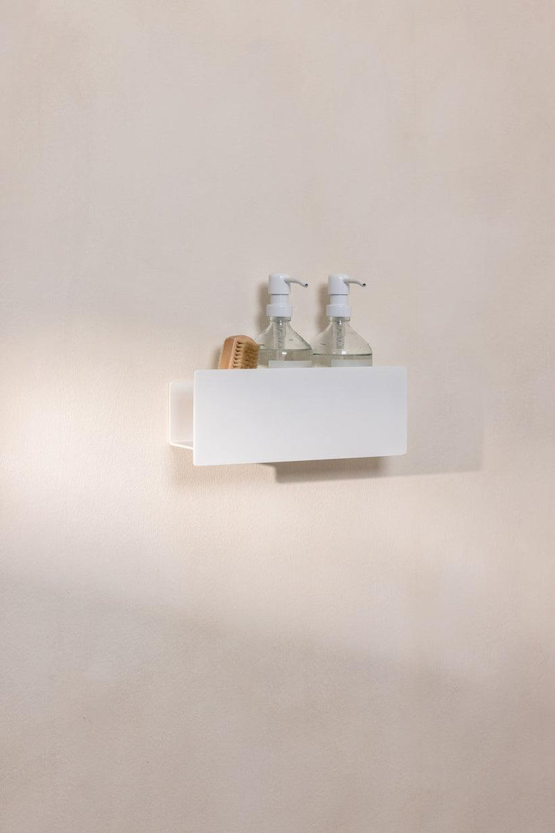 Duschablage SHEA mit dos Seifenspendern und einer Bürste auf einer Wand im Bad.