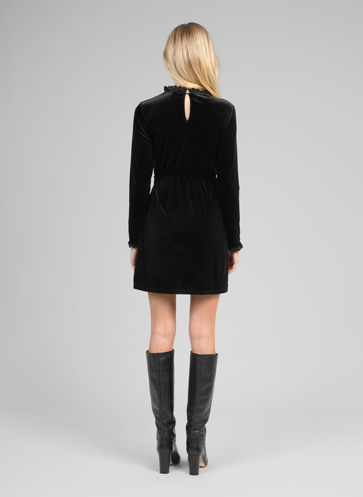 An'ge – Robe Courte Elioty Noir, mannequin de dos portant une robe noire en velours et des bottes