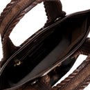 Close-up of a dark brown and cream cow print pattern bag with a dark brown interior. It has an inner pocket with zip. 