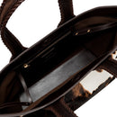 Close-up of a dark brown and cream cow print pattern bag with a dark brown interior. It has an inner pocket with zip. 
