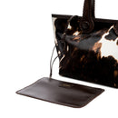 Dark brown and cream cow print pattern tote bag with dark brown rope handles on a white background. It has a  removable inner bag in dark brown.