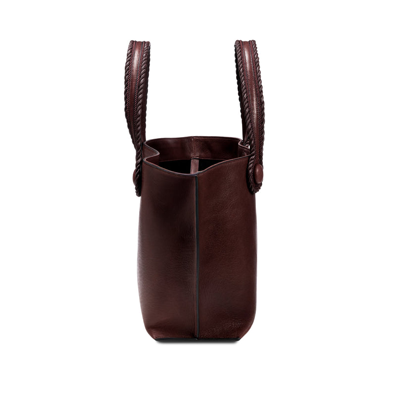 Burgundy leather in a shade of dark cherry tote bag with  an open rope handles on a white background, shown from the side.