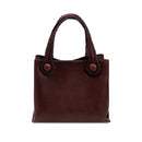 Burgundy leather in a shade of dark cherry tote bag with rope handles on a white background. When the inner straps are joined, the bag takes on a more rounded shape.