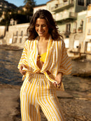 Conjunto de playa compuesto por pantalones fluidos de mujer June y top de playa Gilda Tatiane de Freitas: cintura alta que alarga la silueta, piernas anchas, look sensual de verano, elegantes pantalones de playa Lyon, blusa larga con lazo en el cuello, mangas largas elásticas, rayas estampadas "Eternal Summer Spirit", material ligero y fluido, marca francesa Lyon

