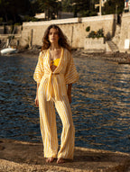 Ensemble de plage un pantalon fluide femme June et un top de plage Gilda  Tatiane de Freitas – taille haute qui allonge une silhouette, jambes larges, look sensuel estival, pantalon plage chic Lyon, chemisier à nouer col long, manches longues élastiques, rayures imprimé "Esprit d'été éternel", matière fluide légère aérienne, marque française Lyon

