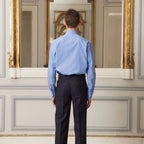Hast – Camicia In Popeline Blu A Righe Sottili Bianche, uomo di spalle che indossa una camicia blu e pantaloni scuri