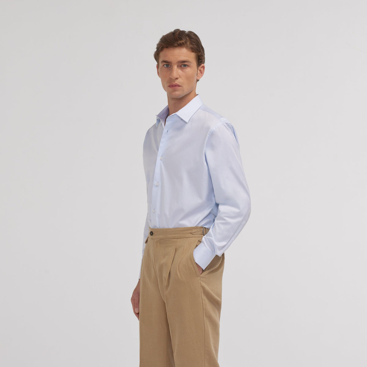 Hast – Camisa de sarga de dos cabos azul celeste, modelo masculino con camisa azul claro y pantalón beis, vista de perfil