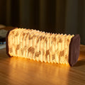 Gingko Design – Lampe Smart Accordion - Velours Marron Zèbre, lampe accordéon lumineuse avec motifs zébrés posée sur une table en bois