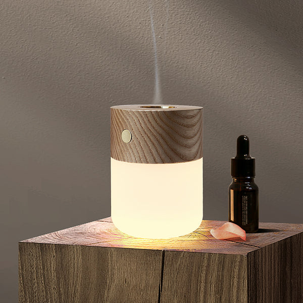 Gingko Design – Lámpara Smart Diffuser - Fresno Blanco, difusor de aceites esenciales de madera clara y vidrio blanco sobre mesa de madera