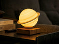 Gingko Design – Smart Saturn Lampe - Walnuss, Nachttischlampe in Form des Planeten Saturn, die über einem Holzsockel schwebt