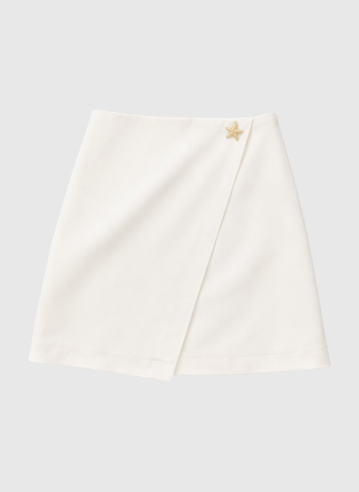 An'ge – Jupe Courte Giovani Ecru, mini-jupe portefeuille blanche avec un détail étoile dorée sur le côté