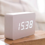 Gingko Design – Brick Click Alarm Clock - White / White LED, light wood digital alarm clock displaying the time on a wooden table