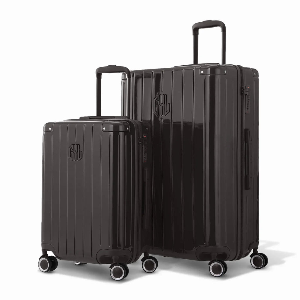 Duo of GYL Intemporelle black rigid suitcases with ribbed shells and telescopic handles. #black_color
