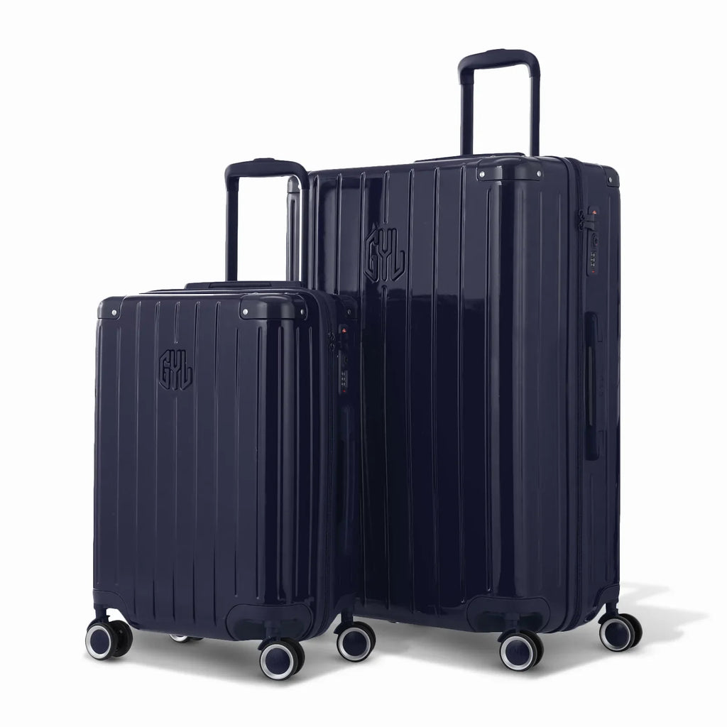 Duo of GYL Intemporelle navy rigid suitcases with ribbed shells and telescopic handles. #navy_color