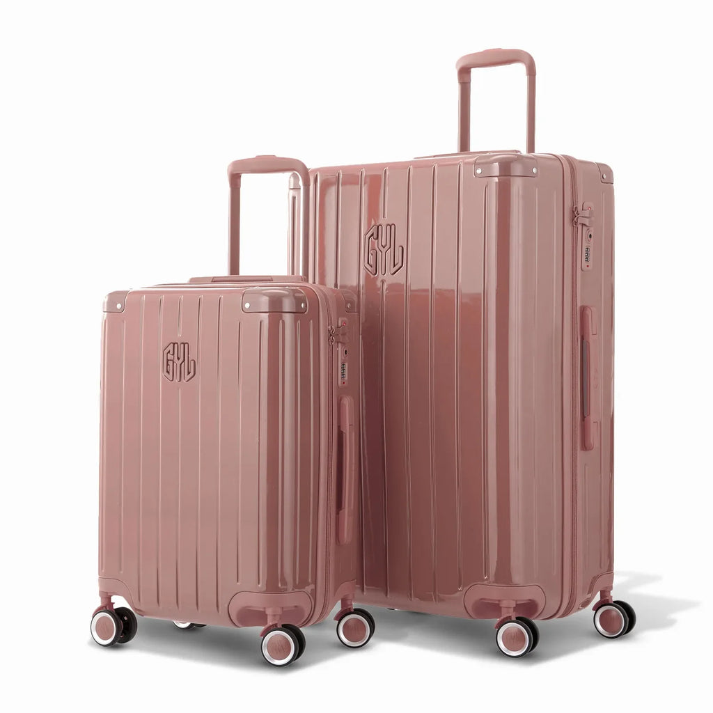 Duo of GYL Intemporelle rose gold rigid suitcases with ribbed shells and telescopic handles. #color_rose gold