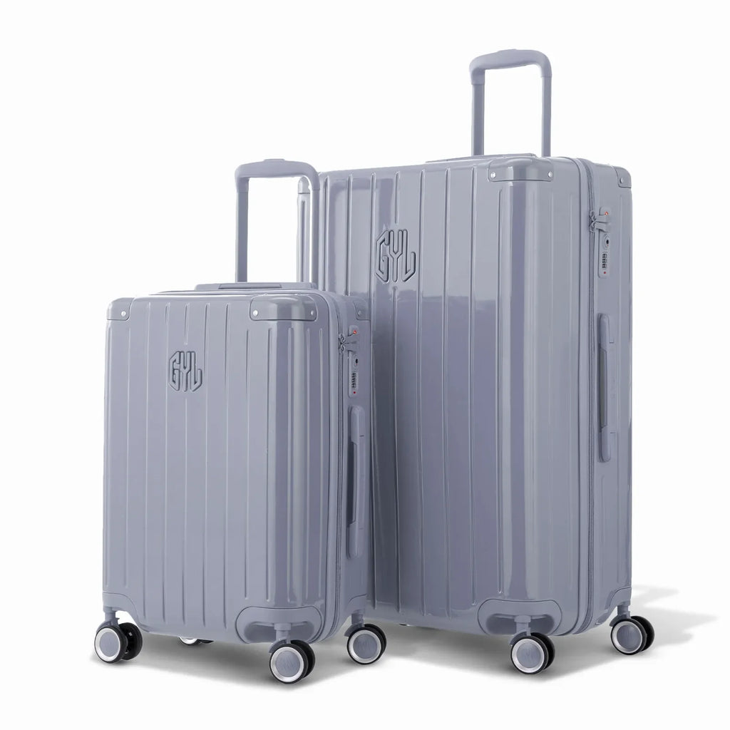 Duo of GYL Intemporelle silver rigid suitcases with ribbed shells and telescopic handles. #silver_color