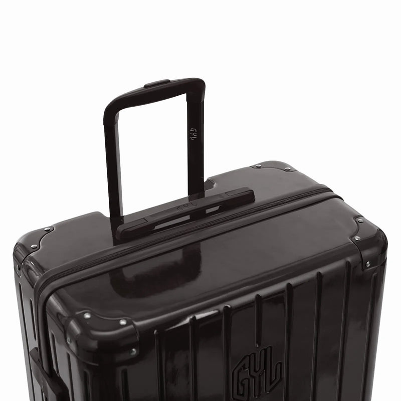 GYL telescopic trolley handle deployed on the Intemporelle black polycarbonate suitcase. #black_color