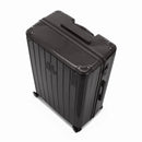 Angled view of the black GYL Intemporelle hardshell suitcase with reinforced corners and shiny ribbed shell. #black_color