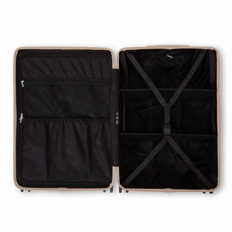 Compartmented interior of the GYL Intemporelle sand suitcase with crossed straps and mesh pockets. #sand_color