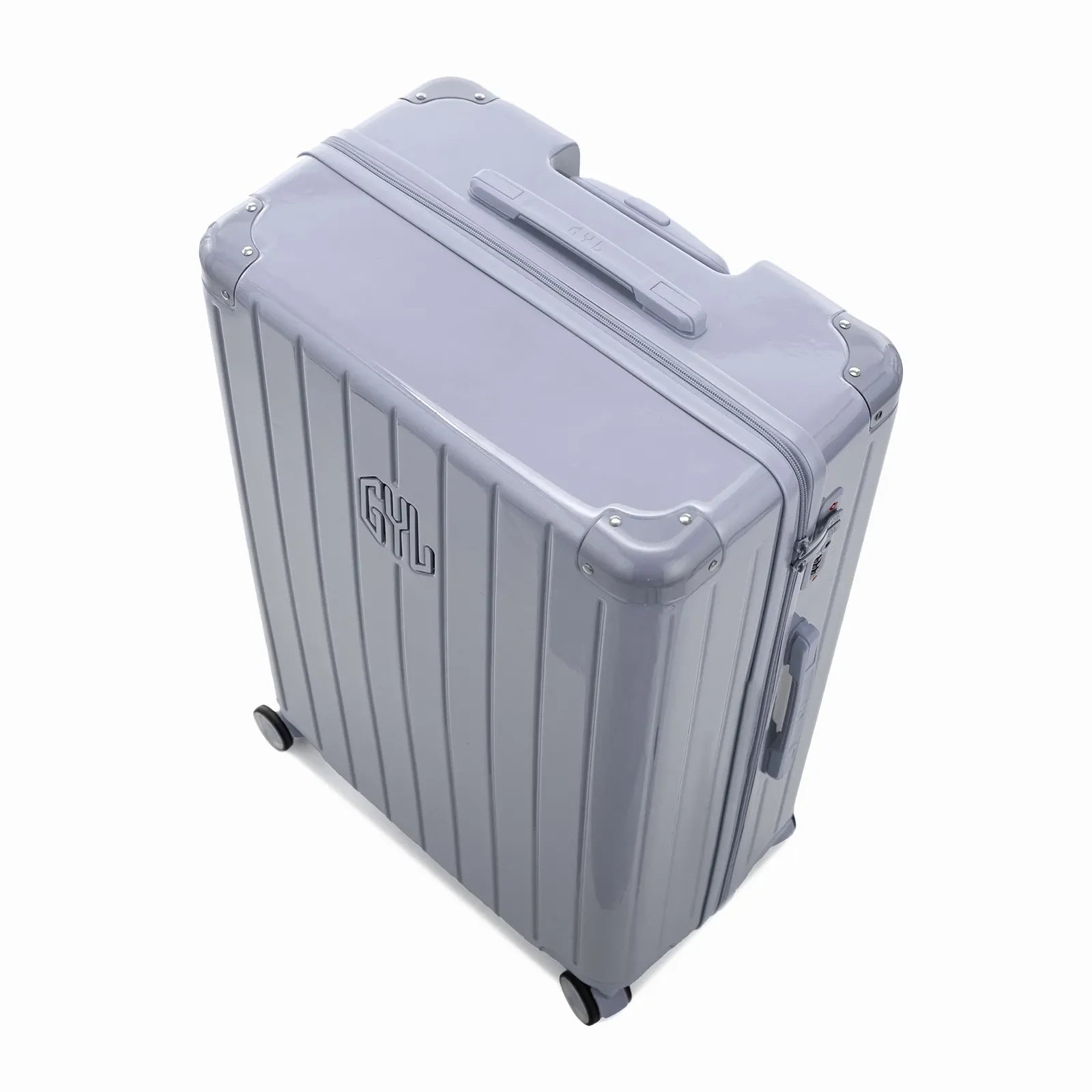 Angled view of the silver GYL Intemporelle hardshell suitcase with reinforced corners and shiny ribbed shell. #silver_color