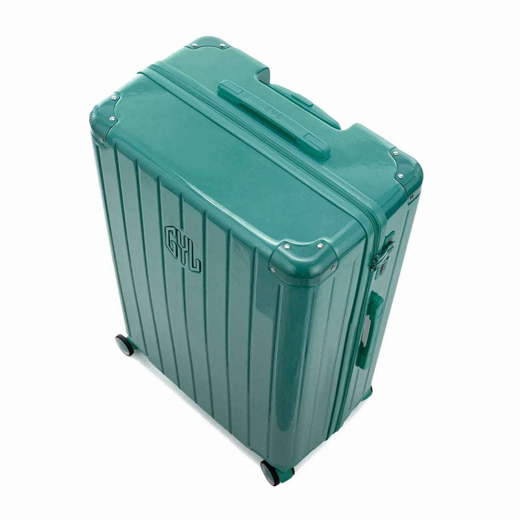 Angled view of the water green GYL Intemporelle hardshell suitcase with reinforced corners and shiny ribbed shell. #color_green