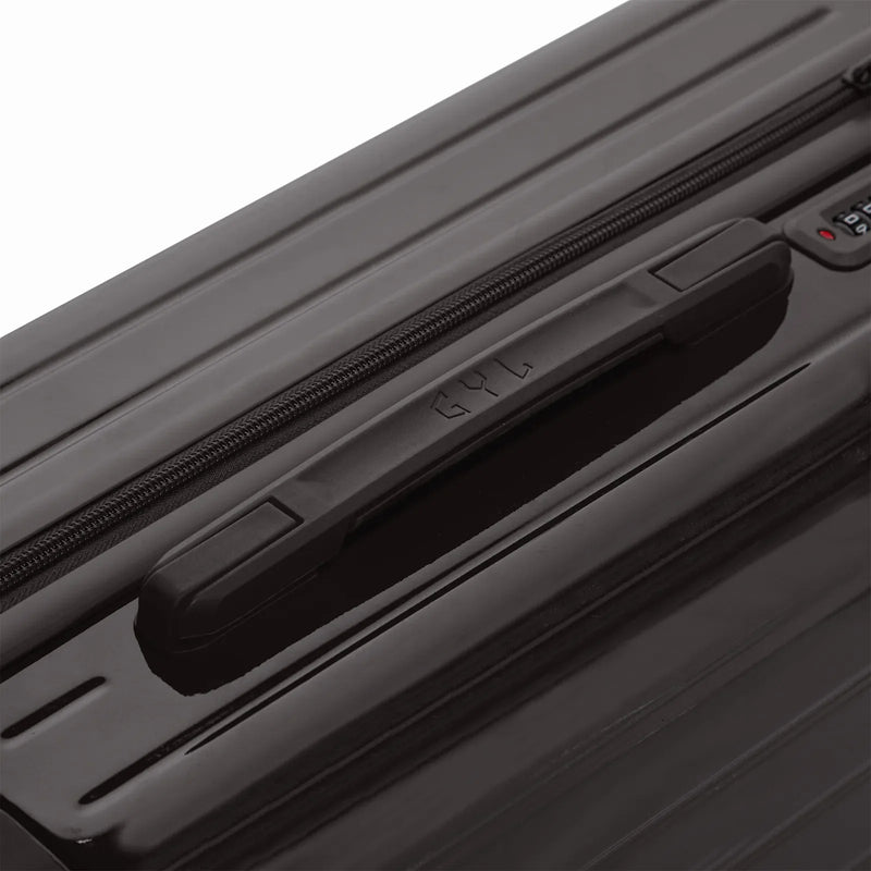 Rigid top handle of the black GYL Intemporelle suitcase with embossed logo on the top. #black_color