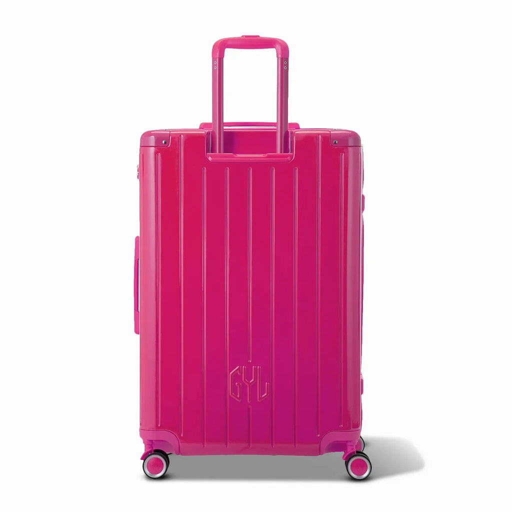 Rear view of the GYL Intemporelle fuchsia hard suitcase with integrated handles and swivel casters. #color_fuchsia