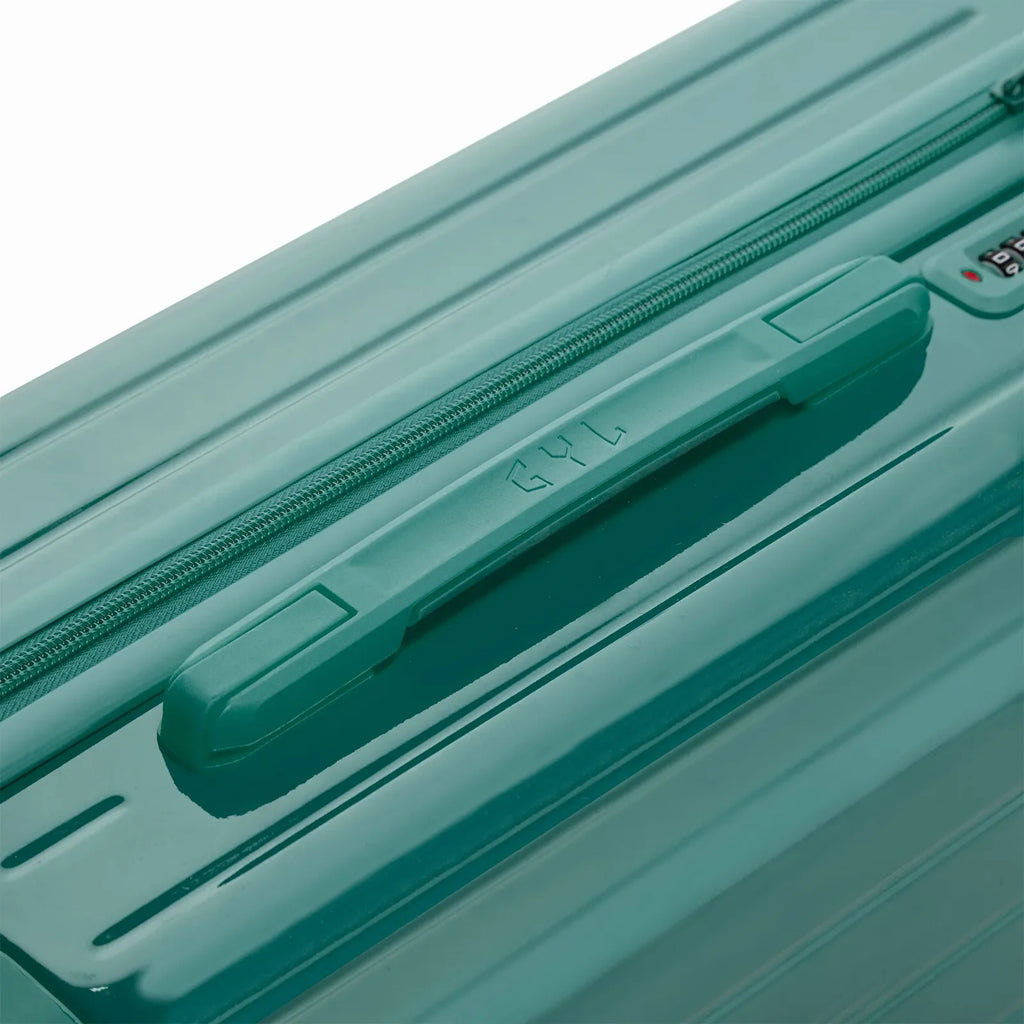 Asa superior rígida de la maleta GYL Intemporelle verde agua con logo en relieve en la parte superior. #couleur_vert